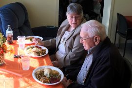 Man and woman having Thanksgiving meal at Adult Day Care Center