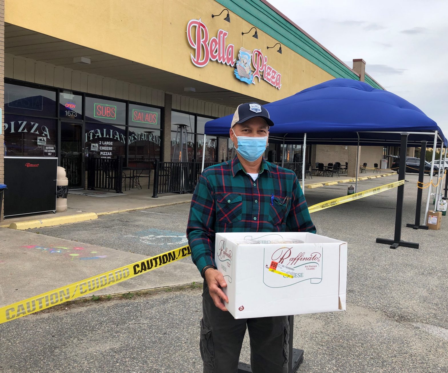 Man carrying box in front of store