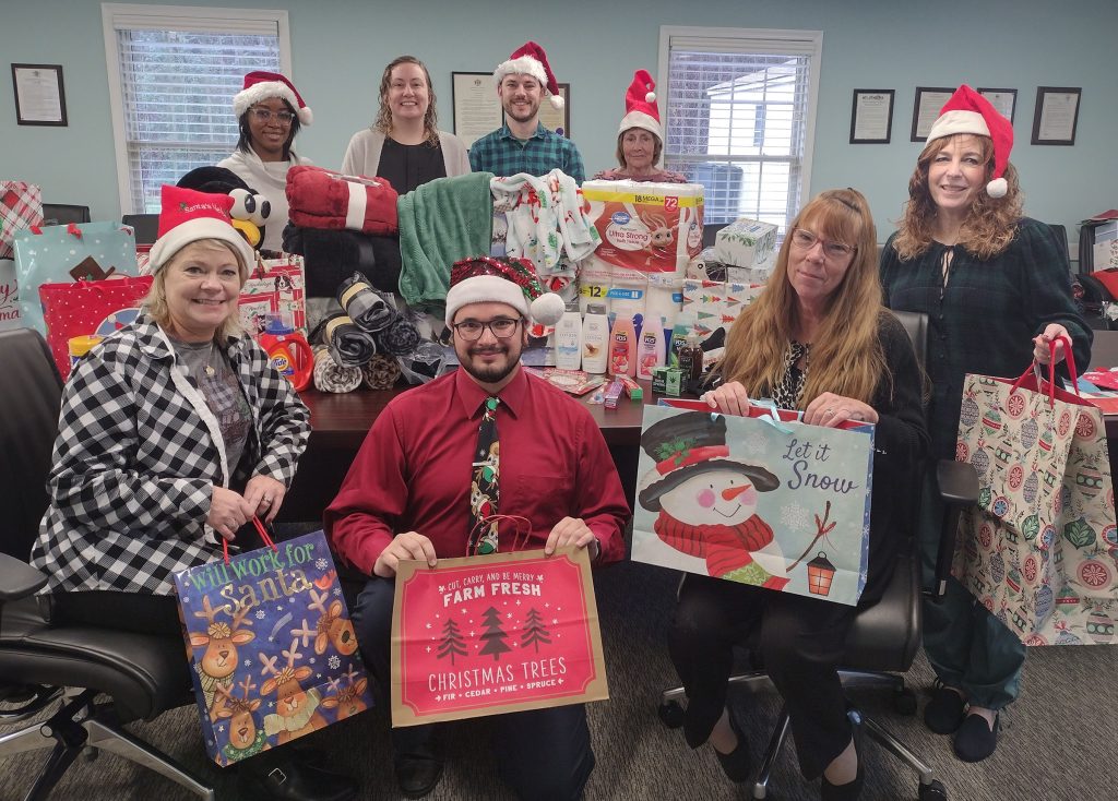 People holding Christmas gift bags