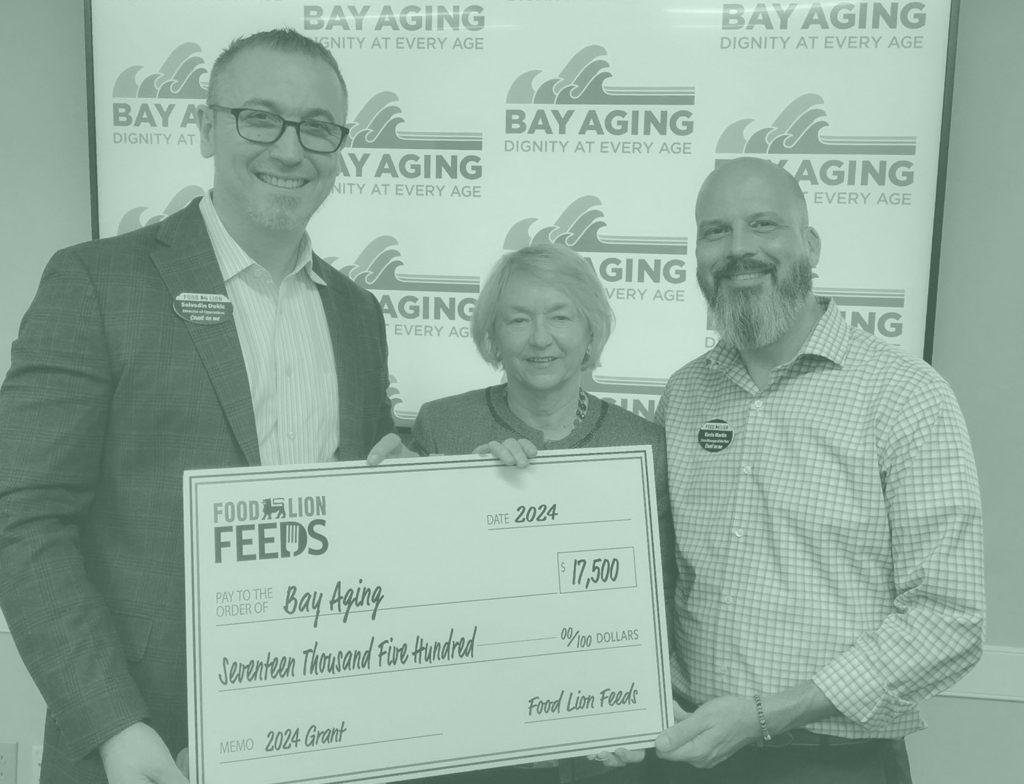 Three people holding donation check