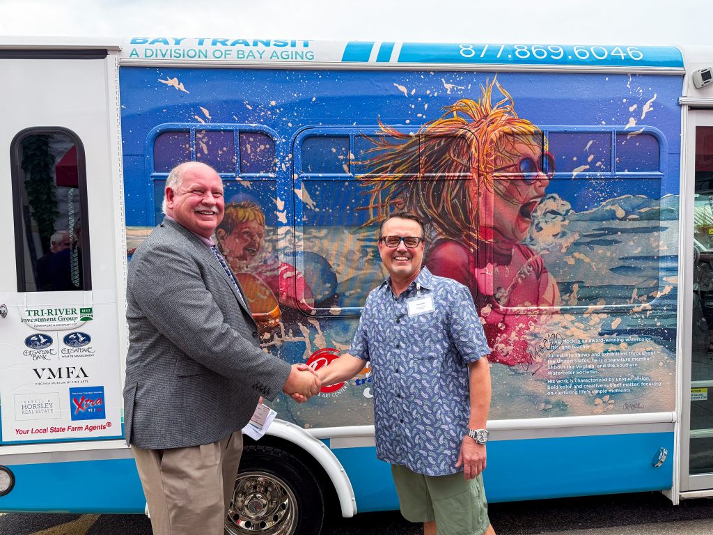 2025-winner-Mock w David Fols crop Two men shaking hands in front of bus with artwork