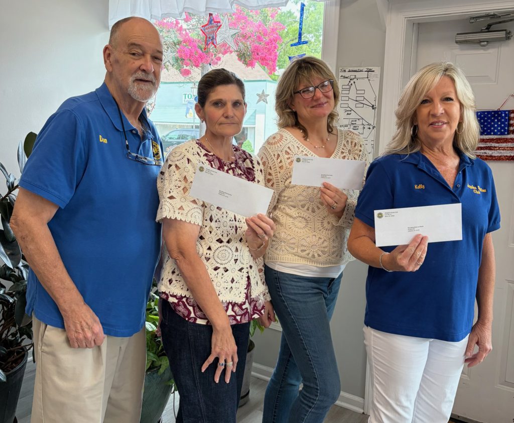 Four people posing for donation picture