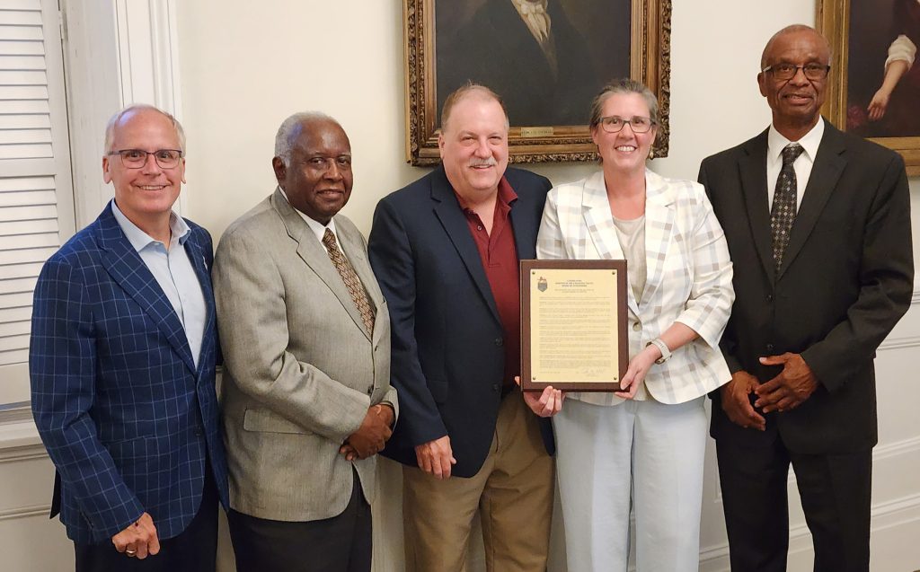 Five people, one holding proclamation