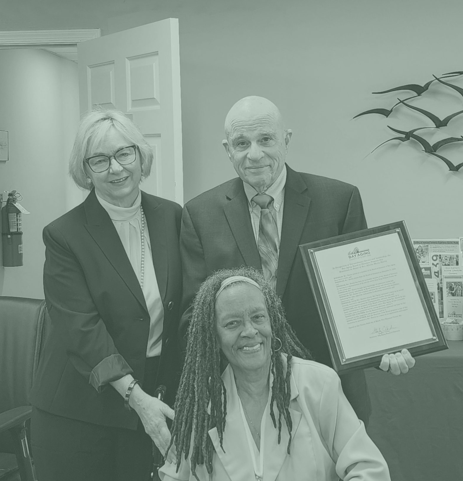 Three people, one holding award