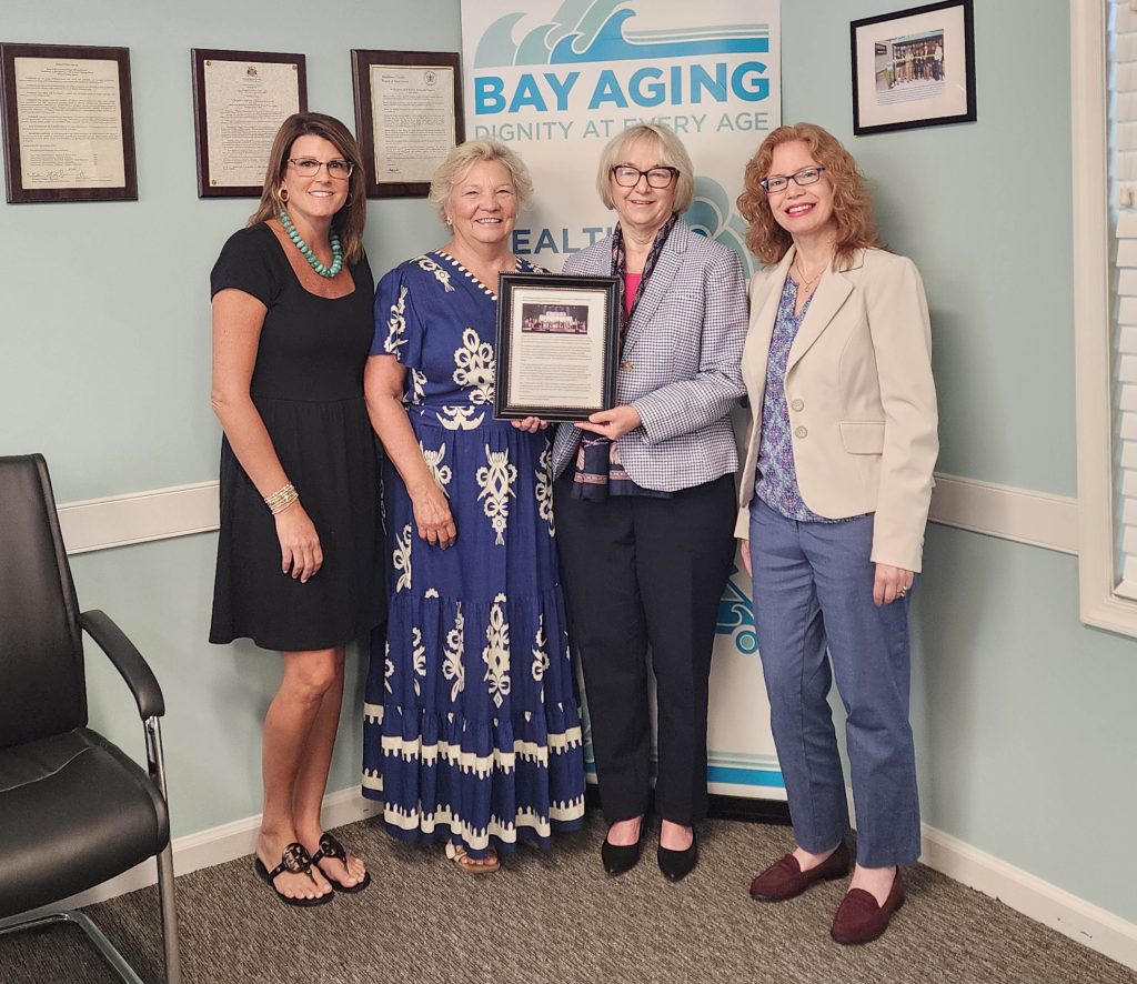 Four women standing holding award