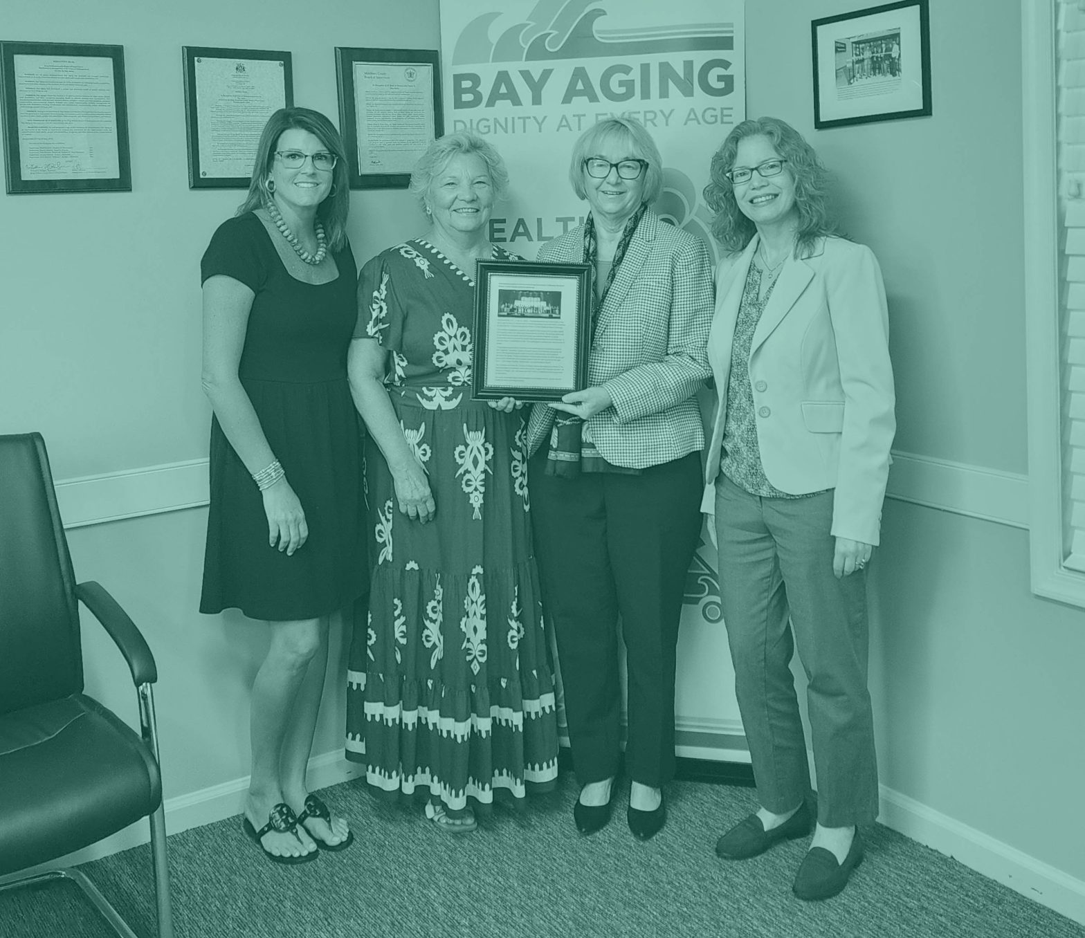 Four women standing holding award