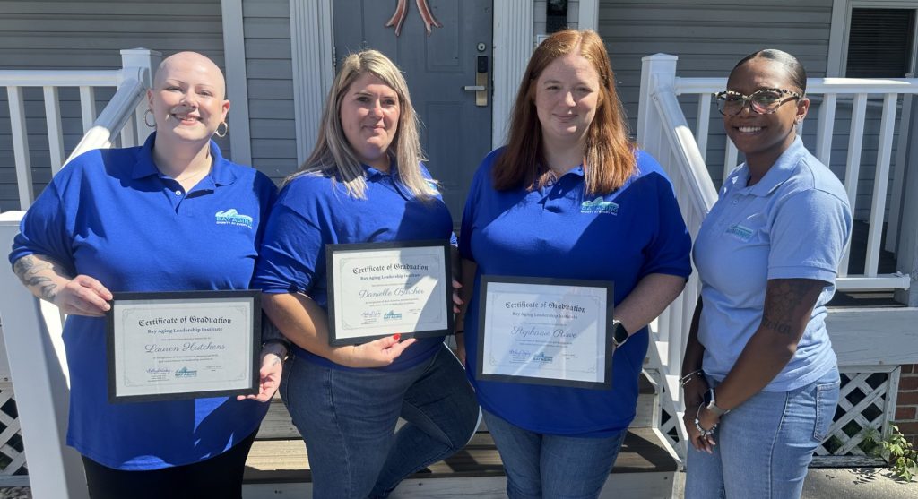 Four woman, three holding certificates